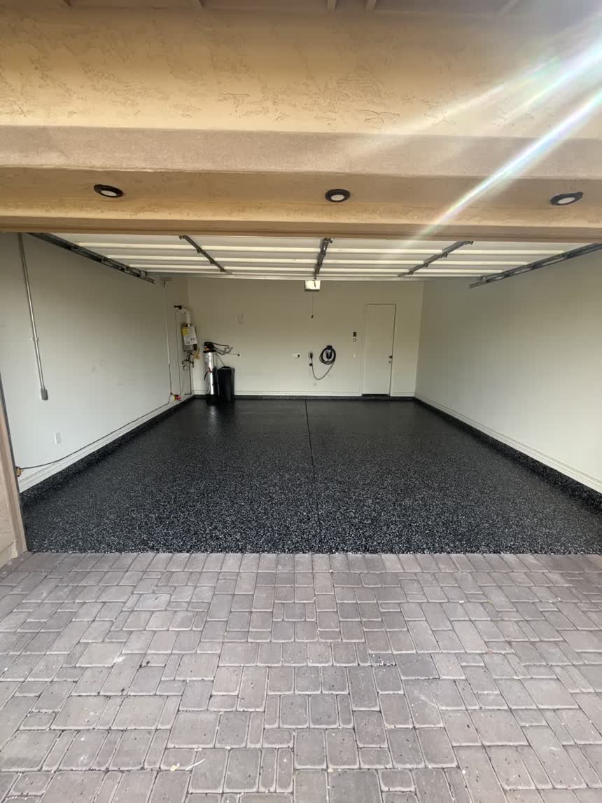 The same garage floor finished with a black, grey and white flake coating and coved stem walls