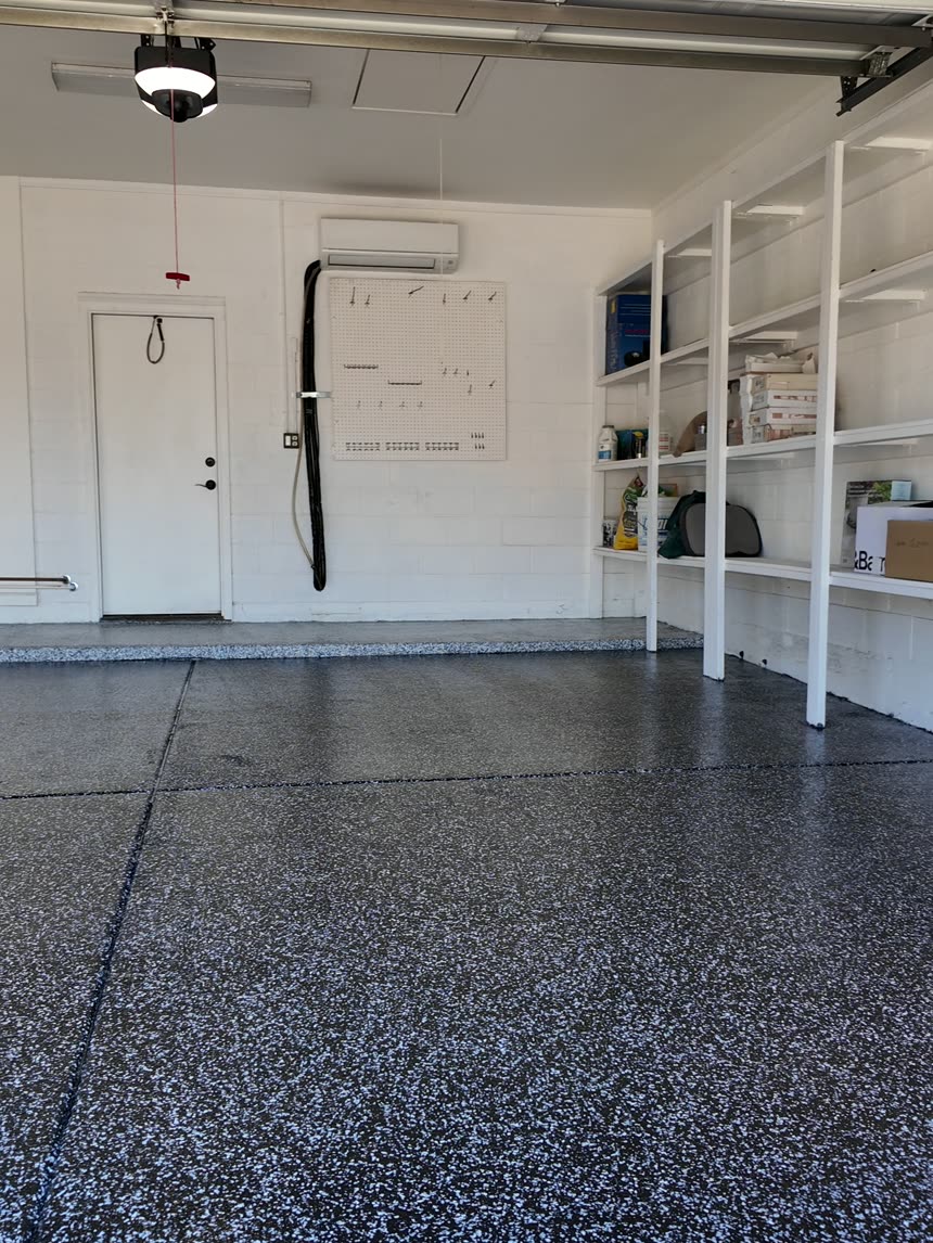 The same garage finished with a black and white flake floor, glossy top coat and coated stem walls